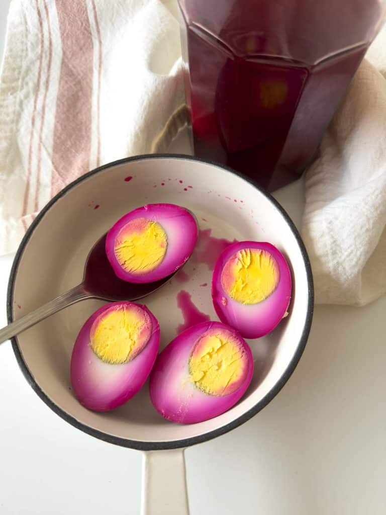 Four halved pickled eggs in a pot.