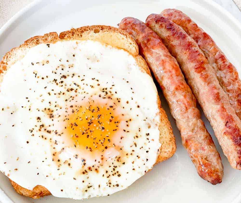 Air-fried sausage, toasted bread, and egg on a plate.