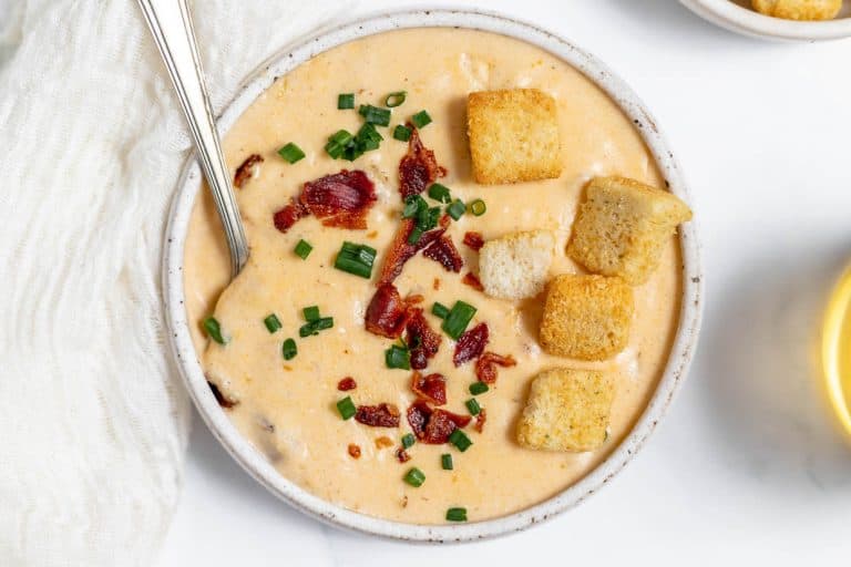 A bowl of soup with croutons on top.