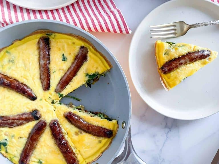 Egg frittata in a skillet with a slice served on a plate.