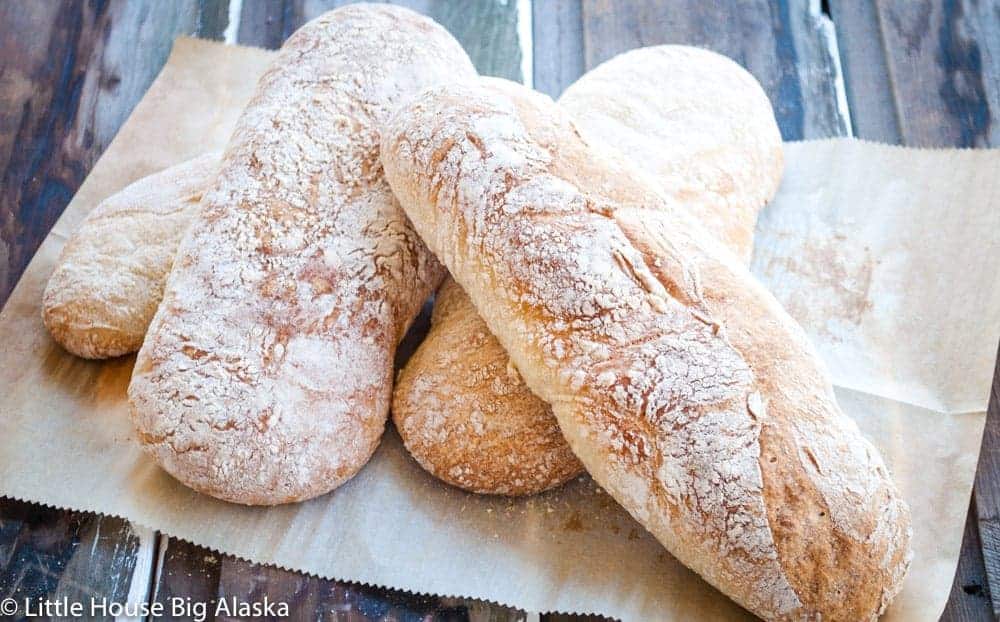 Rustic bread on parchment paper on a wood surface. 
