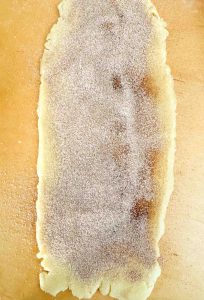 Rolled-out pie crust covered with a layer of cinnamon sugar.