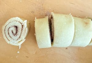 Slices of rolled pie crust filled with cinnamon sugar, ready to bake.