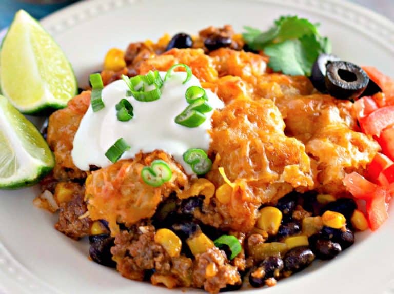 Tater tot taco bake on a plate with sour cream.