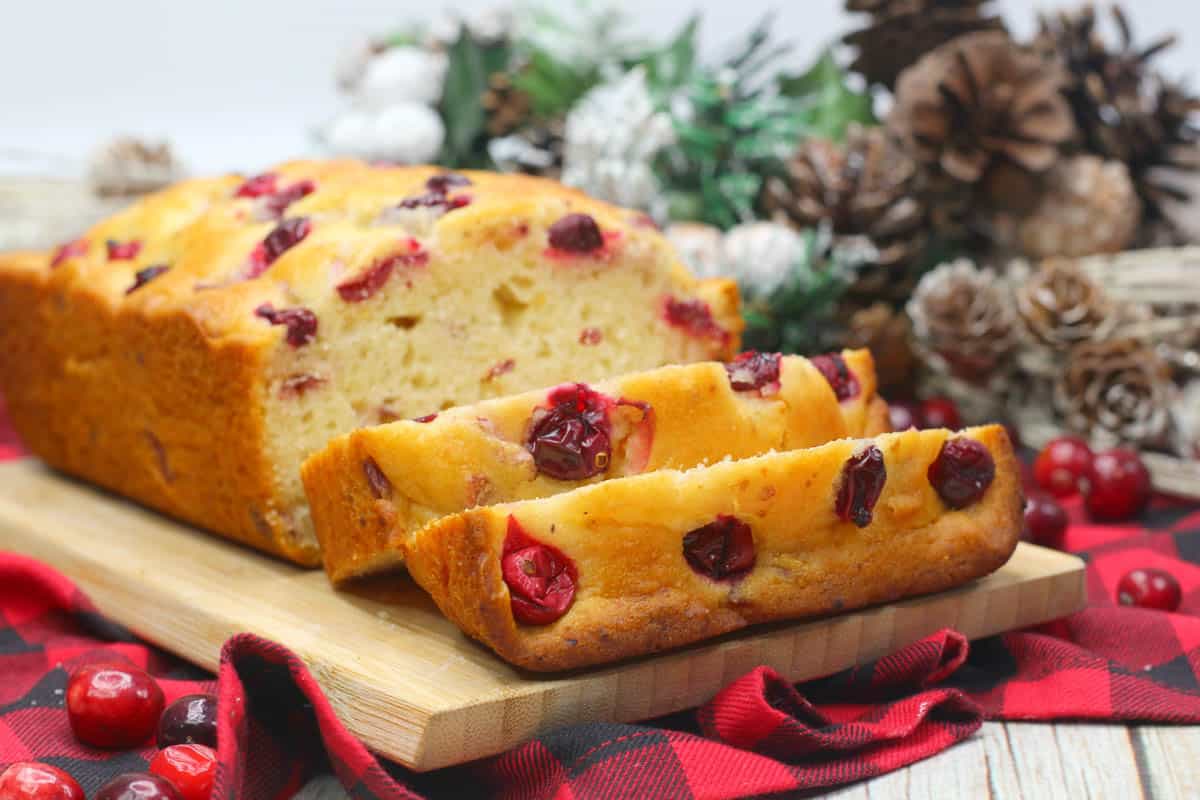 Sliced Orange Cranberry Loaf with holiday decor.