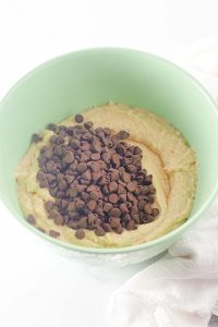 Chocolate chips poured on top of the batter in the bowl.