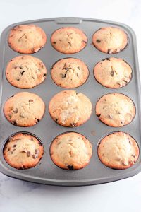 Freshly baked banana chocolate chip muffins in a muffin tin.