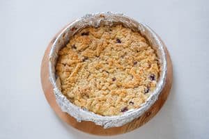 Fully baked blueberry cheesecake crumb cake, cooling in a foil-lined pan.
