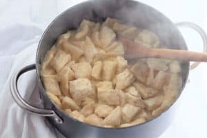 Bite-sized flattened biscuit dough added to the pot.