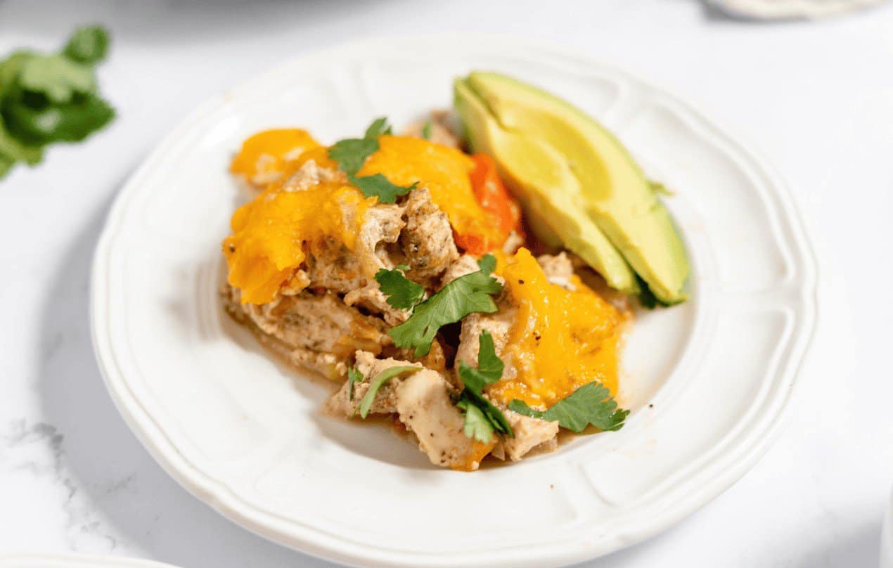 Chicken Fajita Casserole with avocado slices on the side.