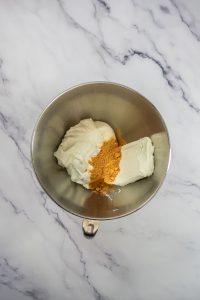Mixing bowl with sour cream, cream cheese, and taco seasoning for easy taco dip.