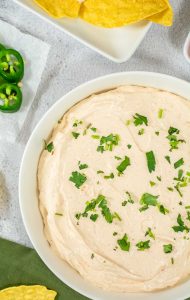 Close-up of easy taco dip with a creamy texture, garnished with cilantro and green onions.