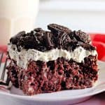 A slice of Oreo poke cake on a white plate.