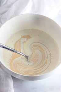 Heavy cream and sweetened condensed milk in a bowl.