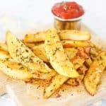 Golden-brown potato wedges with herbs.