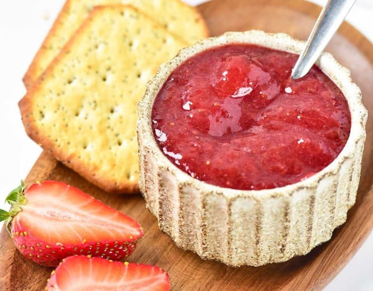 Easy Strawberry Jam served in a small bowl with crackers and strawberries.