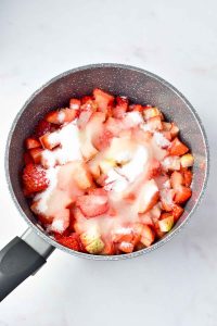 Chopped strawberries, sugar, and lemon juice in a saucepan.