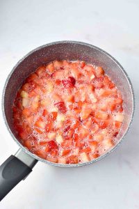 Fruit mixture simmering in a pot for Easy Strawberry Jam.