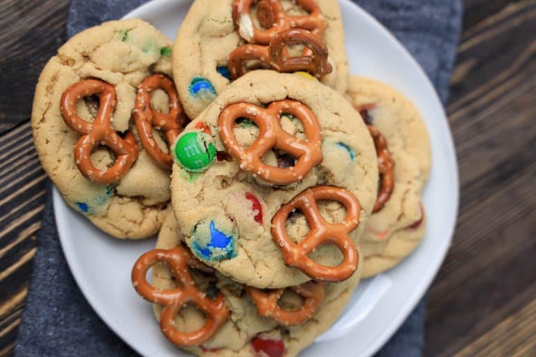 Top-down view of M&M's pretzel cookies on a plate.