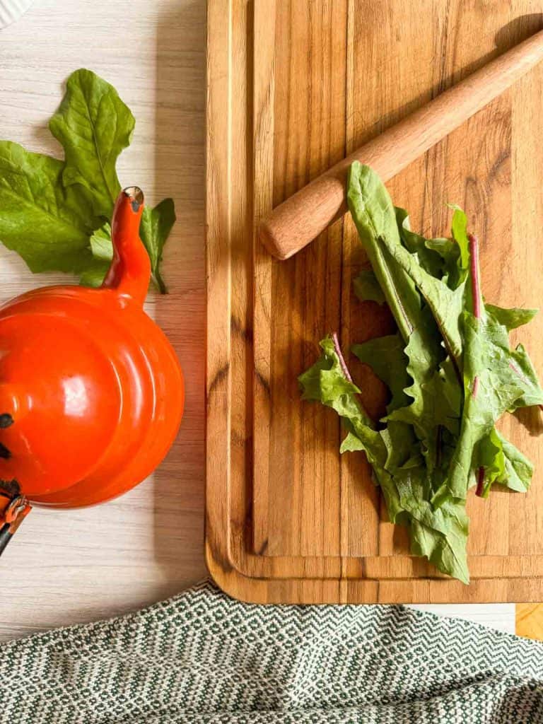 Crushed fresh dandelion greens inside the teapot, ready for steeping.