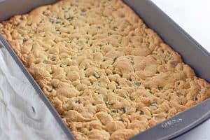 Freshly baked cookie bars still in the pan, golden brown on top.
