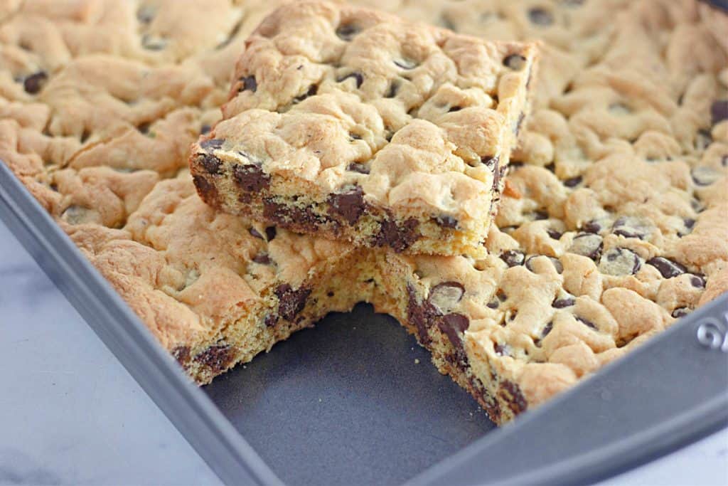 A stack of chocolate chip bars on a cooling sheet.