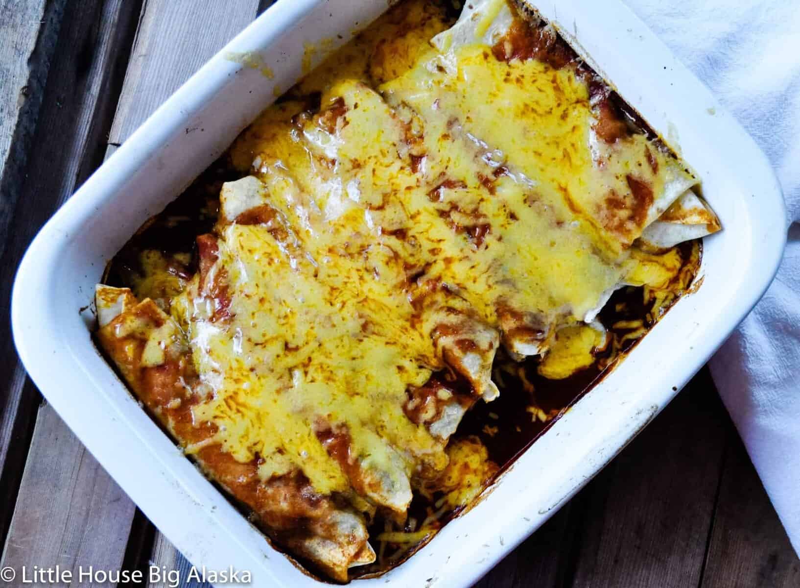 Smothered burritos with melted cheese.