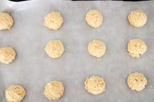 Scooped cookie dough balls on a parchment-lined baking sheet.