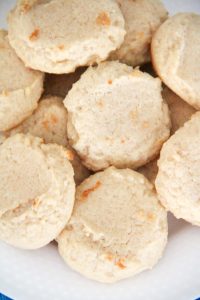Close-up of soft, golden lemonade cookies stacked on a plate.