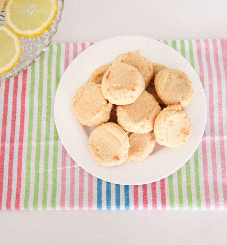 Overhead view of cookies on a plate beside lemon slices.