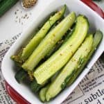 White dish with pickled cucumber spears and dill.