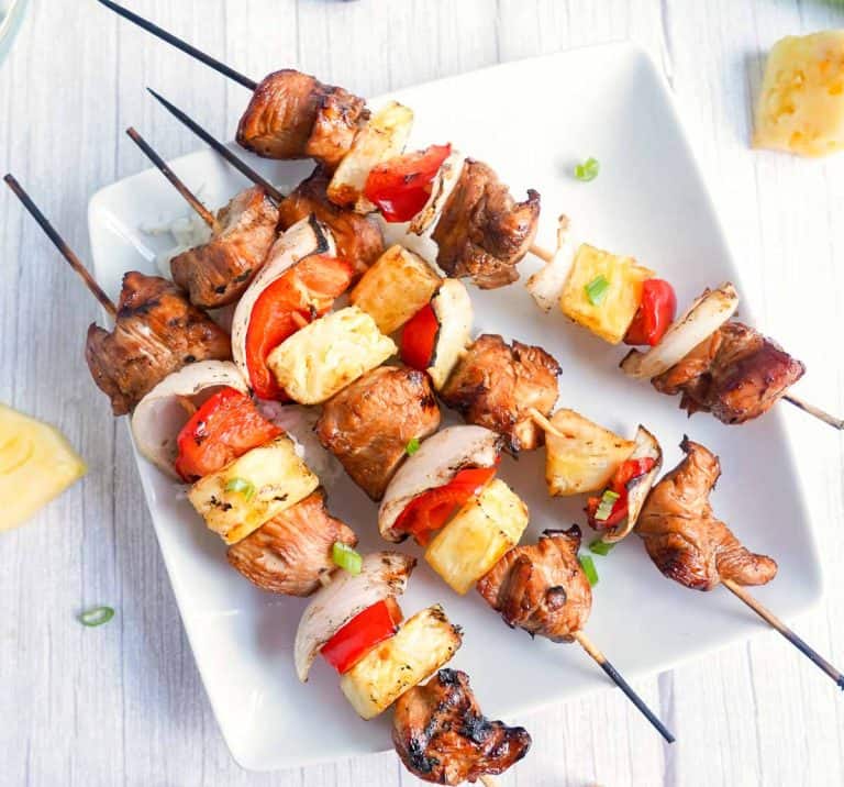 Close-up of grilled chicken teriyaki skewers showing charred edges and juicy vegetables.