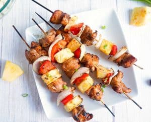 Close-up of grilled chicken teriyaki skewers showing charred edges and juicy vegetables.