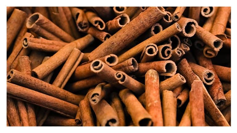 Close-up of whole cinnamon sticks piled together.