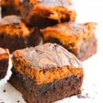 Pumpkin cheesecake brownie square with thick chocolate base and pumpkin top.