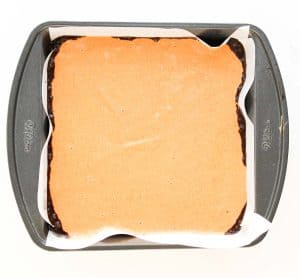 Pumpkin cheesecake layer poured over brownie batter.