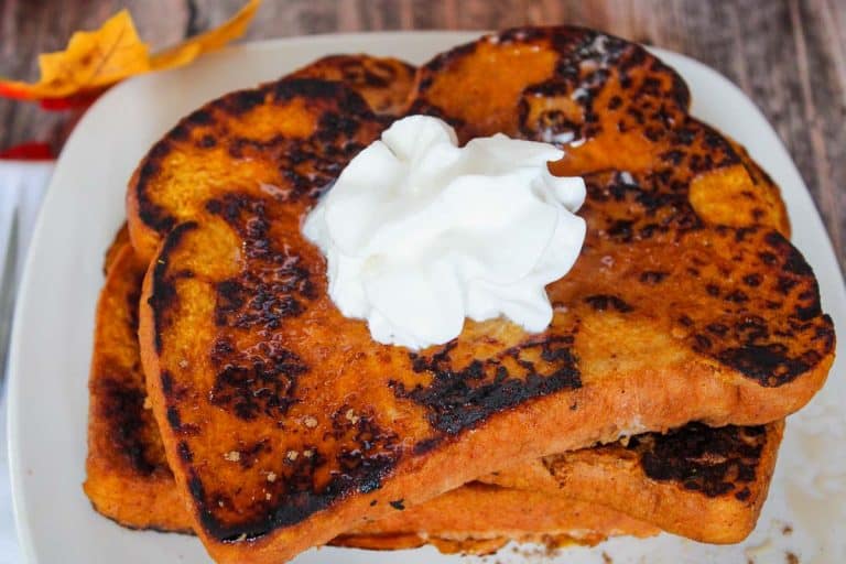 Close-up of pumpkin French toast with syrup and whipped cream.
