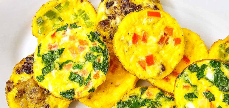 Close-up of colorful mini omelets with spinach, peppers, and sausage.