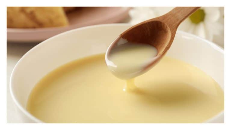 Spoon of sweetened condensed milk over a bowl.