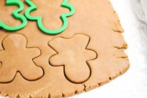 Gingerbread dough rolled out with green gingerbread man cutters.