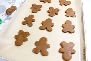 Cut gingerbread cookies arranged on a baking sheet.