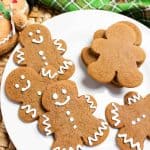 Plate of decorated and plain gingerbread cookies with a green plaid napkin.