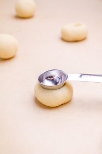 Dough ball pressed in the center with a measuring spoon.