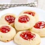 Plate of cream cheese thumbprint cookies arranged neatly.