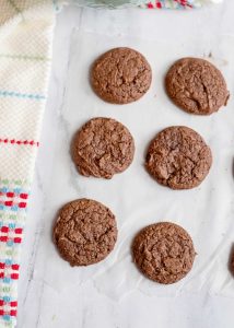 Baked brownie cookies cooling on parchment paper.