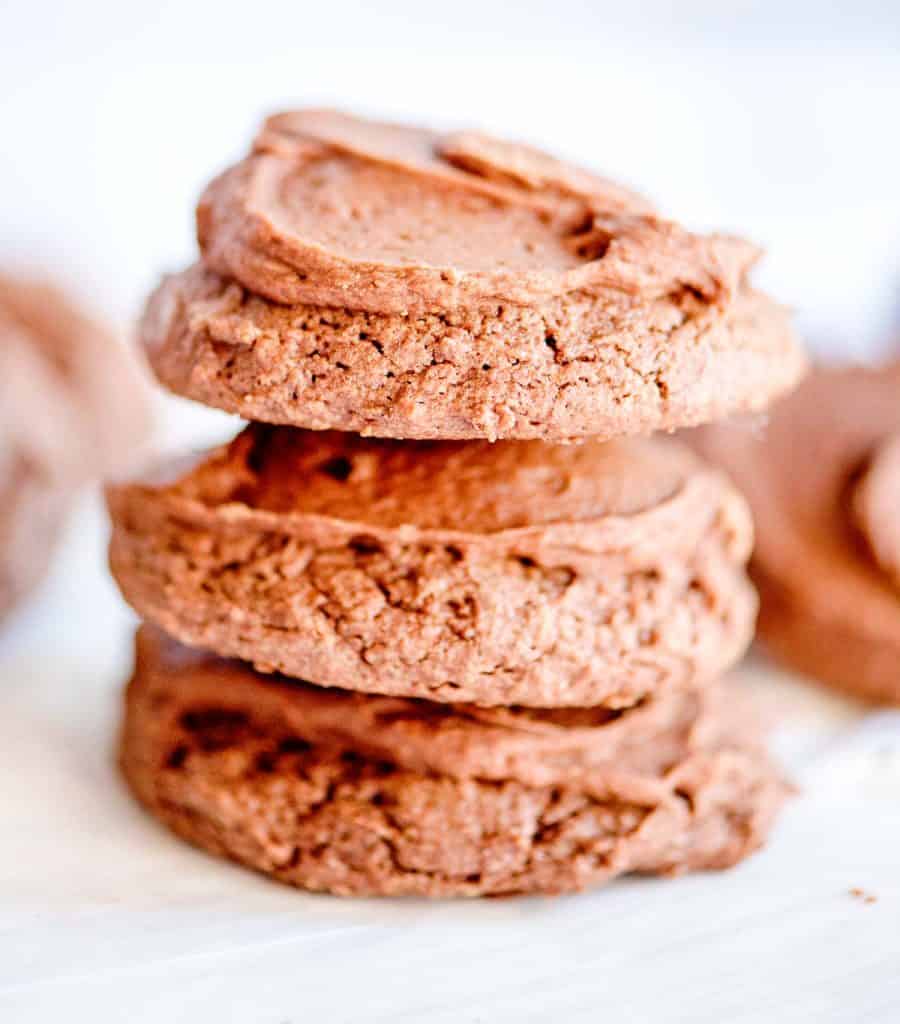 Stack of frosted brownie cookies showing soft texture.