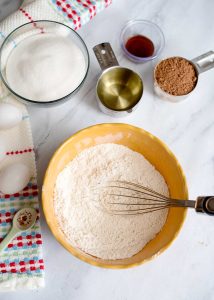 Dry ingredients whisked together in a yellow bowl for brownie cookies.
