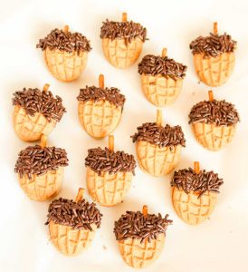Finished Nutter Butter acorn cookies with pretzel stems and sprinkles.