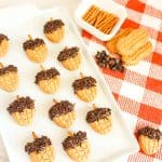 Tray of Nutter Butter acorns with ingredients and cloth underneath.