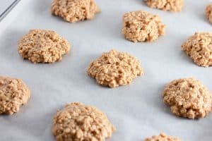 Close-up of peanut butter no-bake cookies cooling on parchment paper.